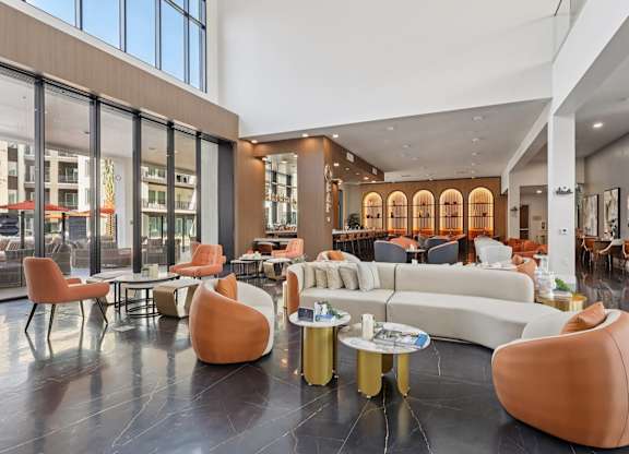 A modern living room with a white couch and orange chairs.