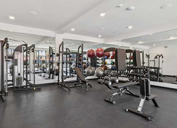 A gym with a variety of equipment including weights and machines.