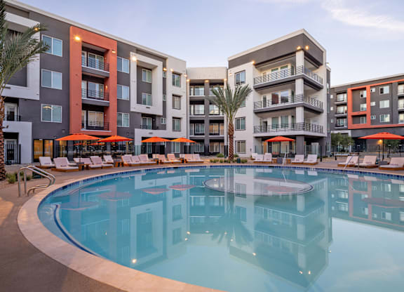 A large swimming pool in front of apartment buildings.