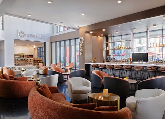A modern lounge area with a bar in the background.