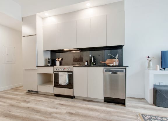a kitchen with white cabinets and a stainless steel stove and refrigerator