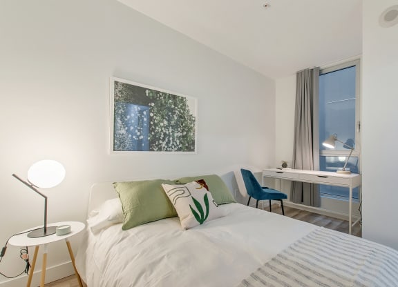 a bedroom with a bed and a desk with a chair