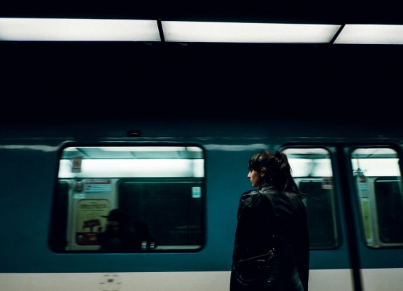 a woman standing in front of a subway train