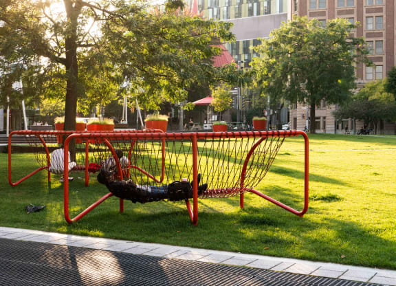 a person laying on a swing in a park