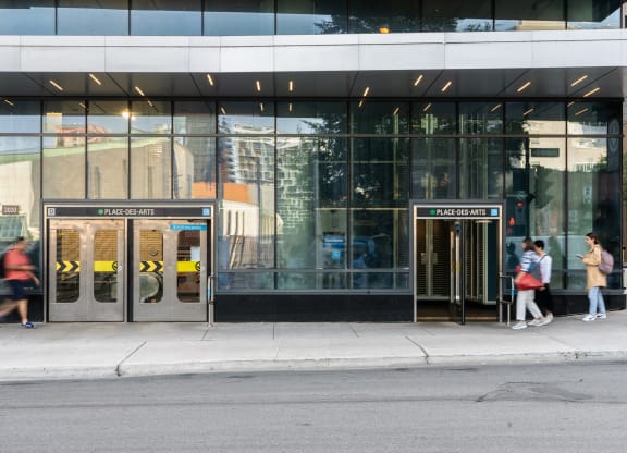 people walking in front of a building with doors