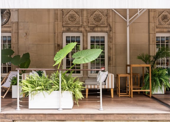 a terrace with chairs and potted plants in front of a building