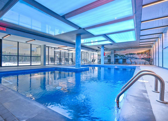 a swimming pool in the middle of a building with glass walls