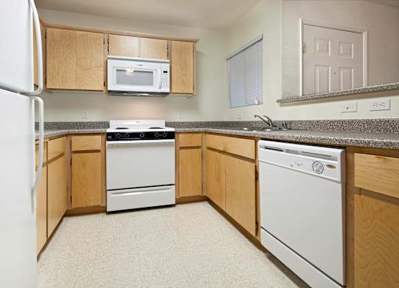 a kitchen with white appliances and wooden cabinets