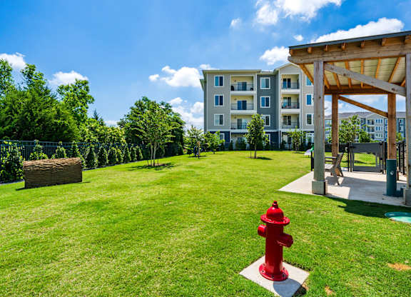 A red fire hydrant sits in the middle of a grassy area.