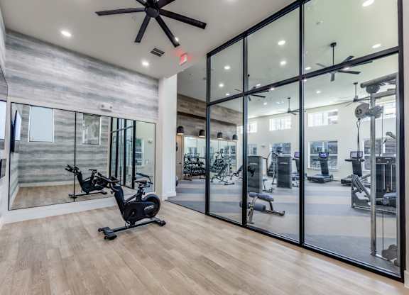 A gym with a wood floor and a glass wall.