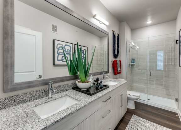 A bathroom with a white sink and a white toilet.