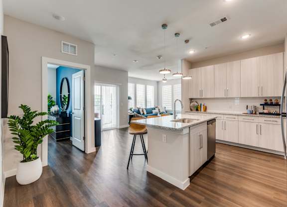 A modern kitchen with a large island and wooden floors.