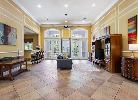 A spacious living room with a large tiled floor and a ceiling fan.