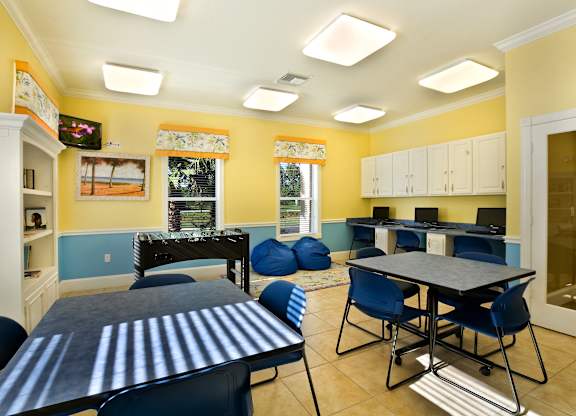 a recreation room with tables and chairs and a foosball table
