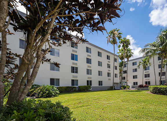 a large white building with a grassy area in front of it