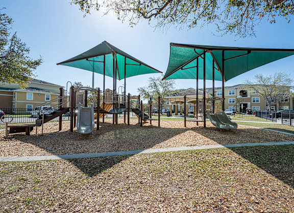 A playground with a swing set and a green canopy.
