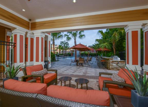 Outdoor lounge area near the grilling area by the pool at The Amalfi Clearwater Apartments