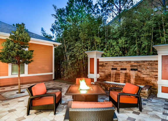 a backyard patio at The Amalfi Clearwater Apartmentswith a fire pit and chairs at The Amalfi in Clearwater Apartments, FL