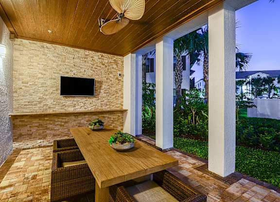 Outdoor dining area with a TV at Azura in Kendall, FL