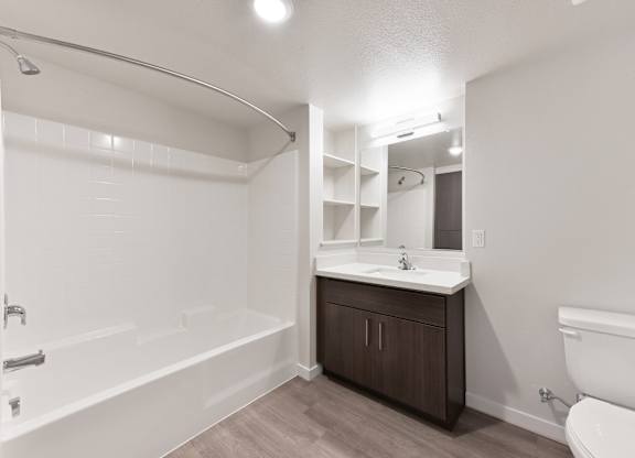 A white bathroom with a white toilet, sink, and bathtub.