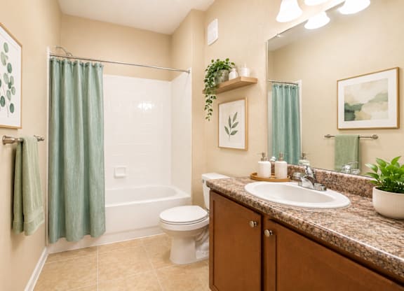 A bathroom with a toilet, sink, and shower.