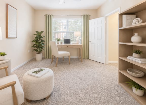 A cozy living room with a chair, ottoman, and bookshelf.