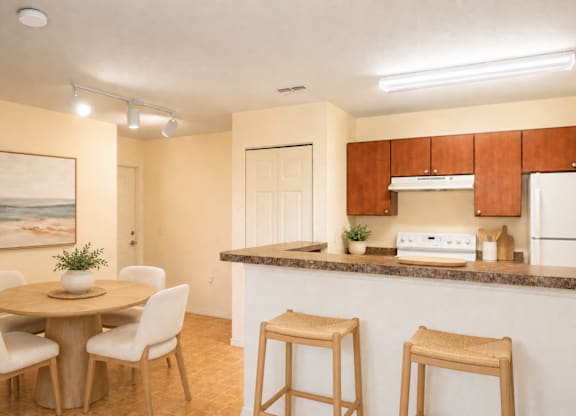 A kitchen with a table and chairs and a painting on the wall.