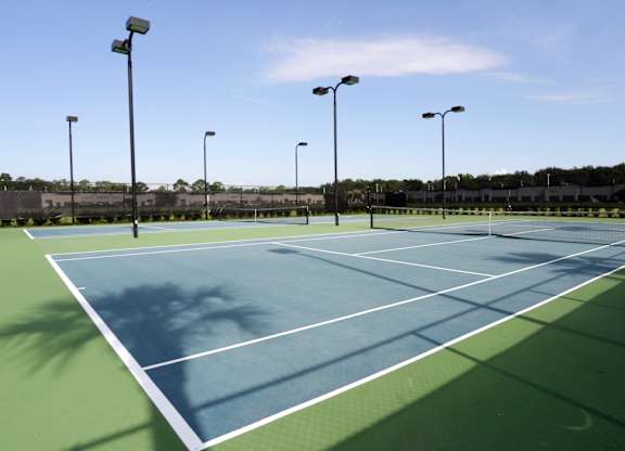 A tennis court with a blue surface and white lines.