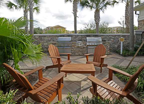 Four wooden chairs and a table are arranged on a patio.
