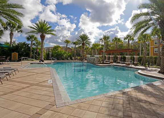 A large swimming pool surrounded by palm trees.