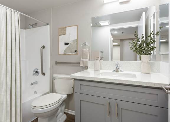 A white toilet with a white sink and a white cabinet.