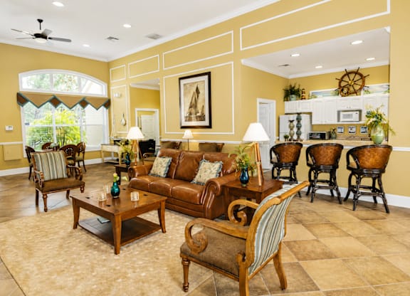 A living room with a brown couch and a painting on the wall.