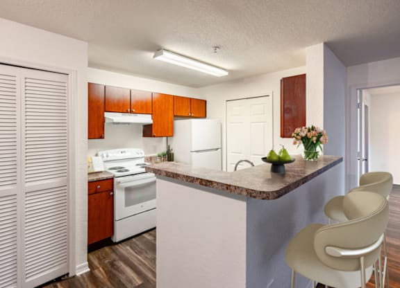 A kitchen with a white counter top and a white stove.