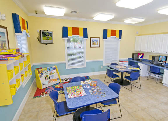a play room with tables and chairs and games