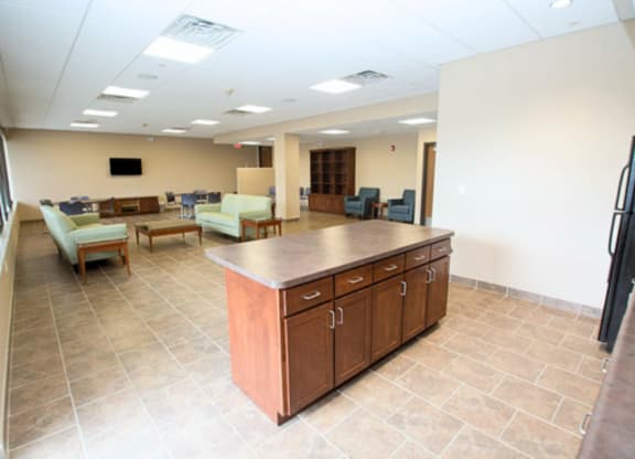 A spacious room with a kitchen island and seating area.