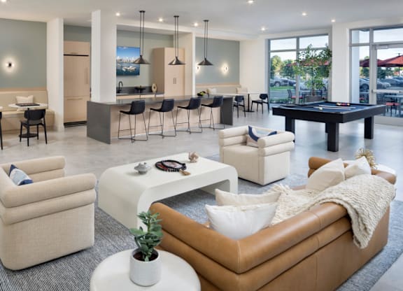 A living room with a pool table and a bar area.