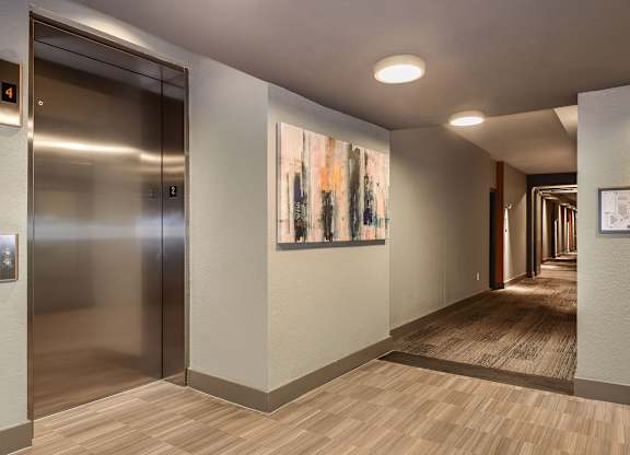 a hallway with a door to a elevator and a painting on the wall  at Grady Square, Florida, 33607