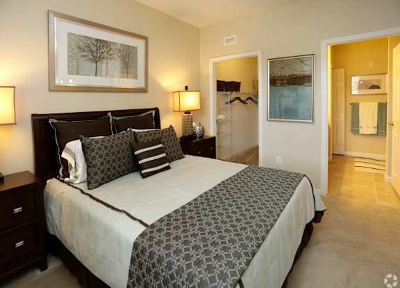 A bedroom with a large bed and a painting on the wall.