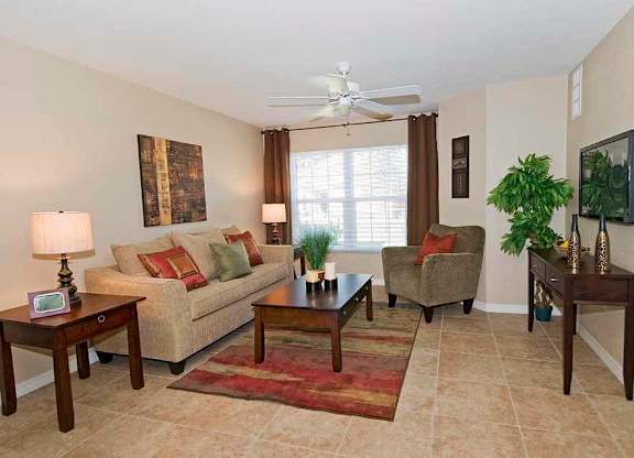 a living room filled with furniture and a ceiling fan