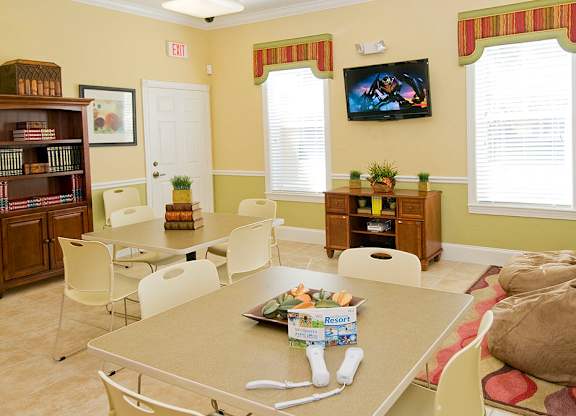 a living room with a table and chairs and a tv