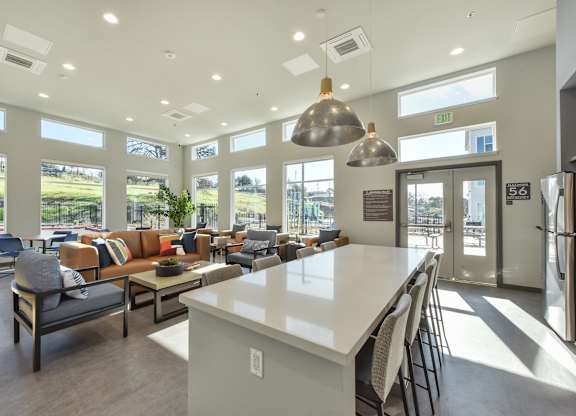 A large, well-lit room with a kitchen island and multiple seating areas.