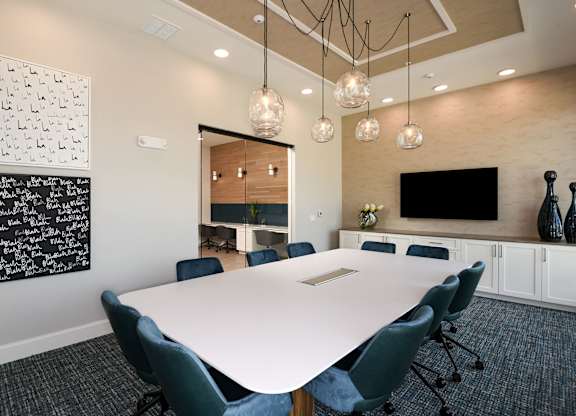 A conference room with a white table and blue chairs.