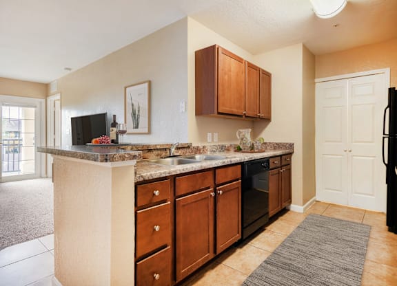 A kitchen with brown cabinets and a granite countertop.