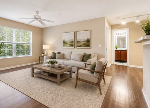 A living room with a couch, a coffee table, and a ceiling fan.