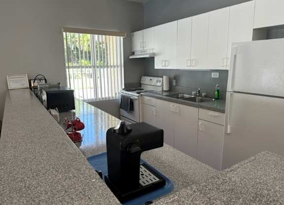 a kitchen with a white refrigerator freezer next to a stove top oven