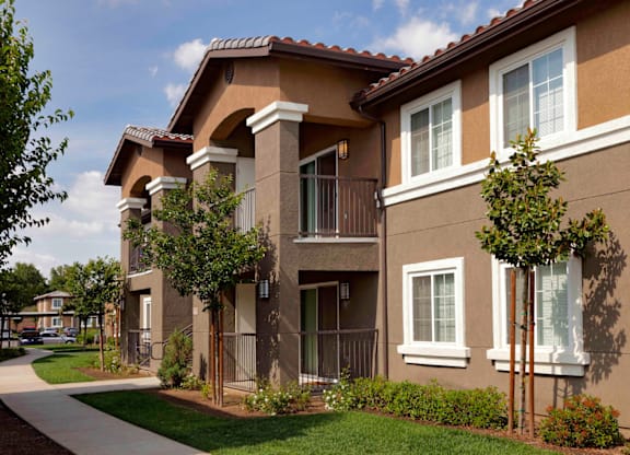 an apartment building with a sidewalk in front of it