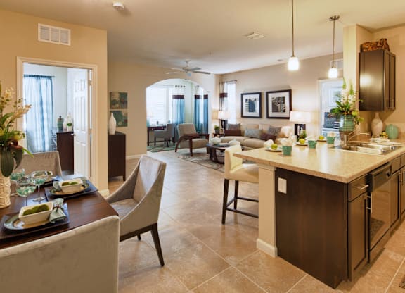 A well-lit, modern kitchen and dining area with a table set for two.