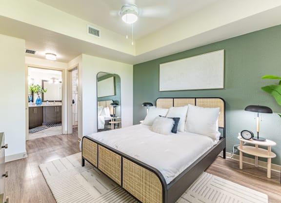 A bedroom with a large bed and a mirror on the wall.