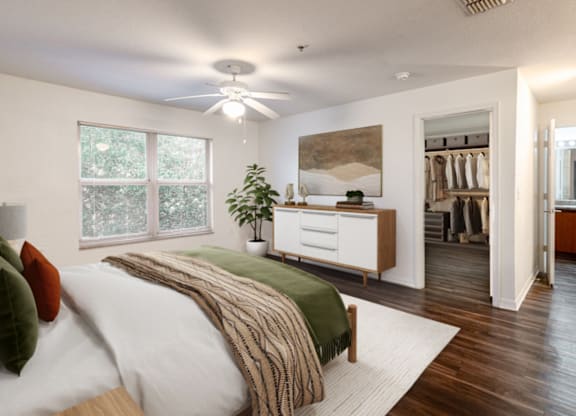 A bedroom with a bed, a dresser, and a ceiling fan.