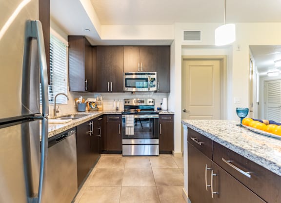 A modern kitchen with a stainless steel refrigerator and a stove top oven.